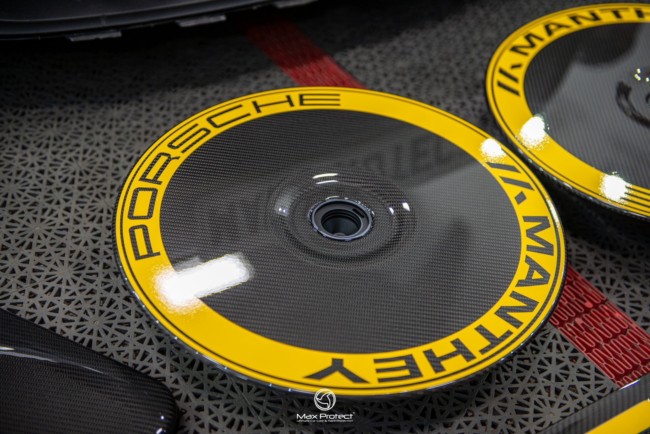 Close-up of Manthey Racing MR mud flap decal for Porsche GT3 RS in carbon and yellow